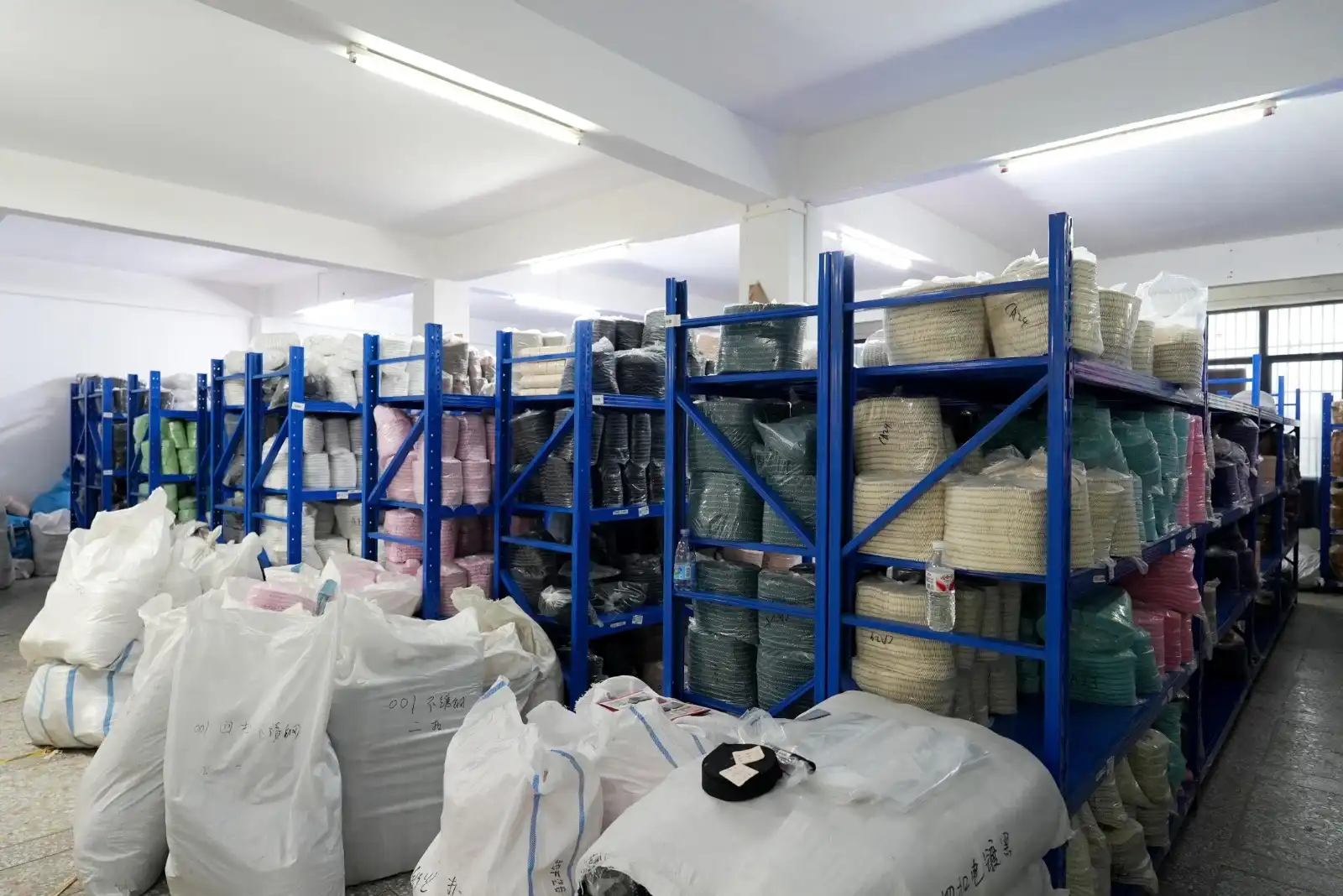 Fabric warehouse with organized rolls of materials on shelves