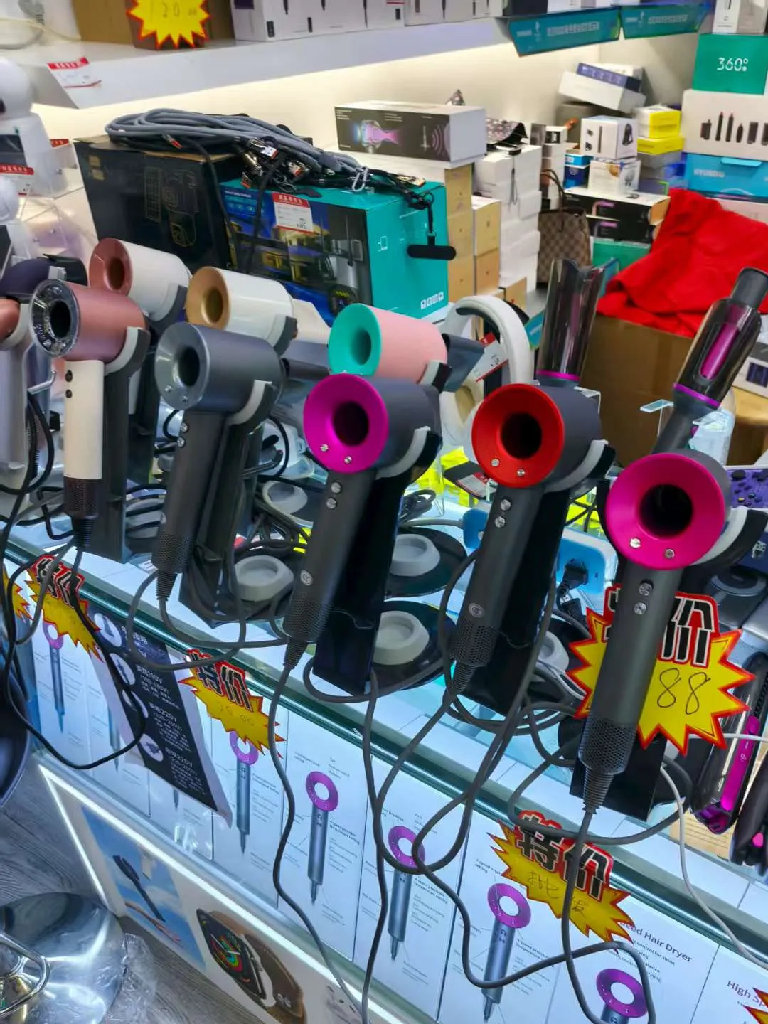 Wide display of consumer electronics gadgets including hair dryer, power bank, earphones and gaming console at a Huaqiangbei vendor counter
