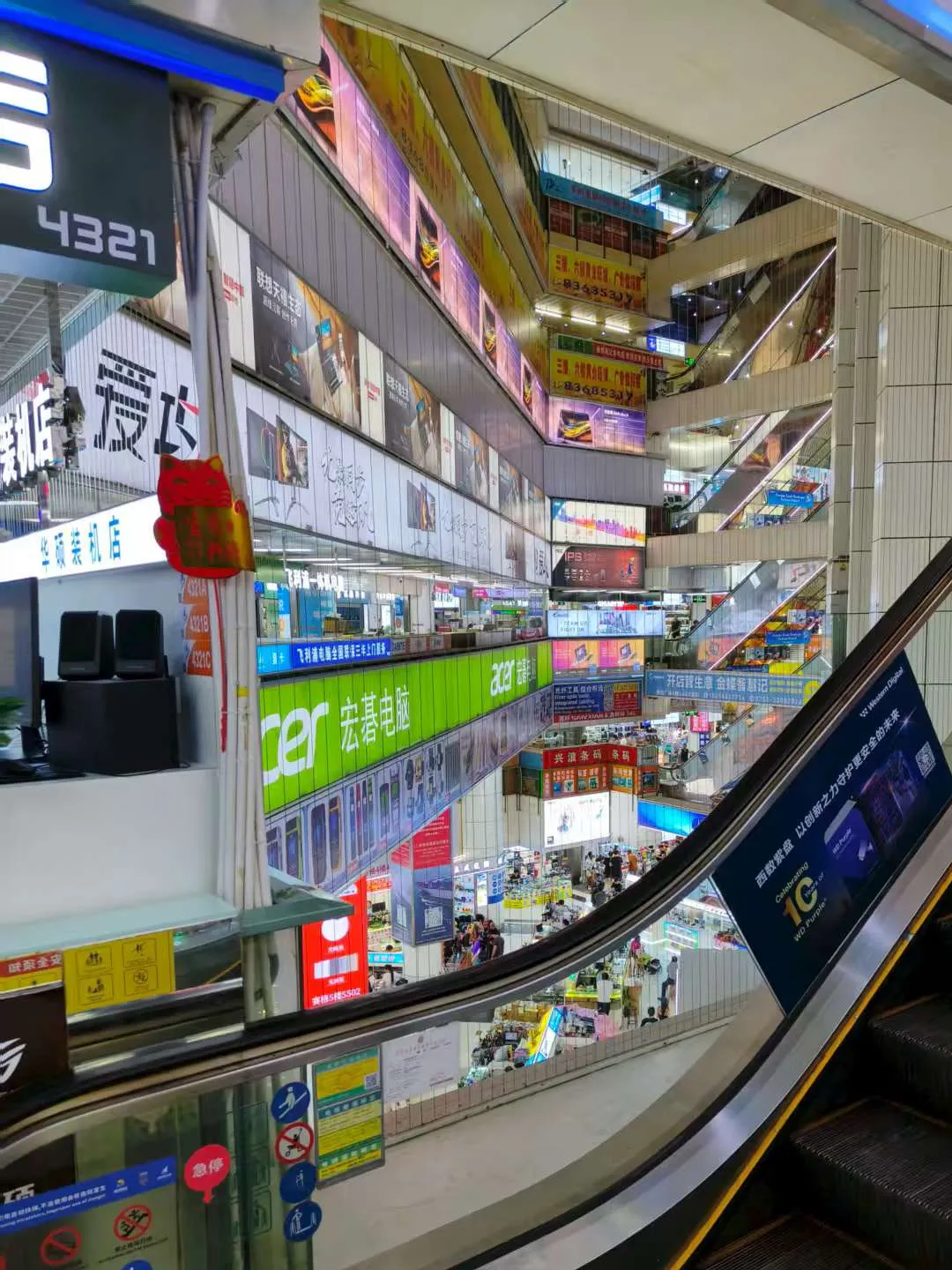 Interior of Huaqiangbei electronics market in Shenzhen, wide shot showing multiple floors of vendor counters